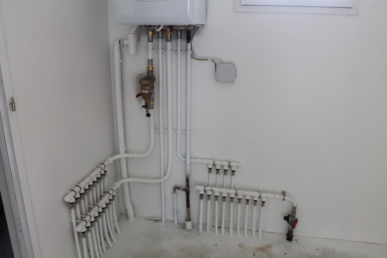 tuyauterie sous la chaudire: tuyaux radiateurs  gauche, tuyaux robinets eau chaude et eau froide  droite.