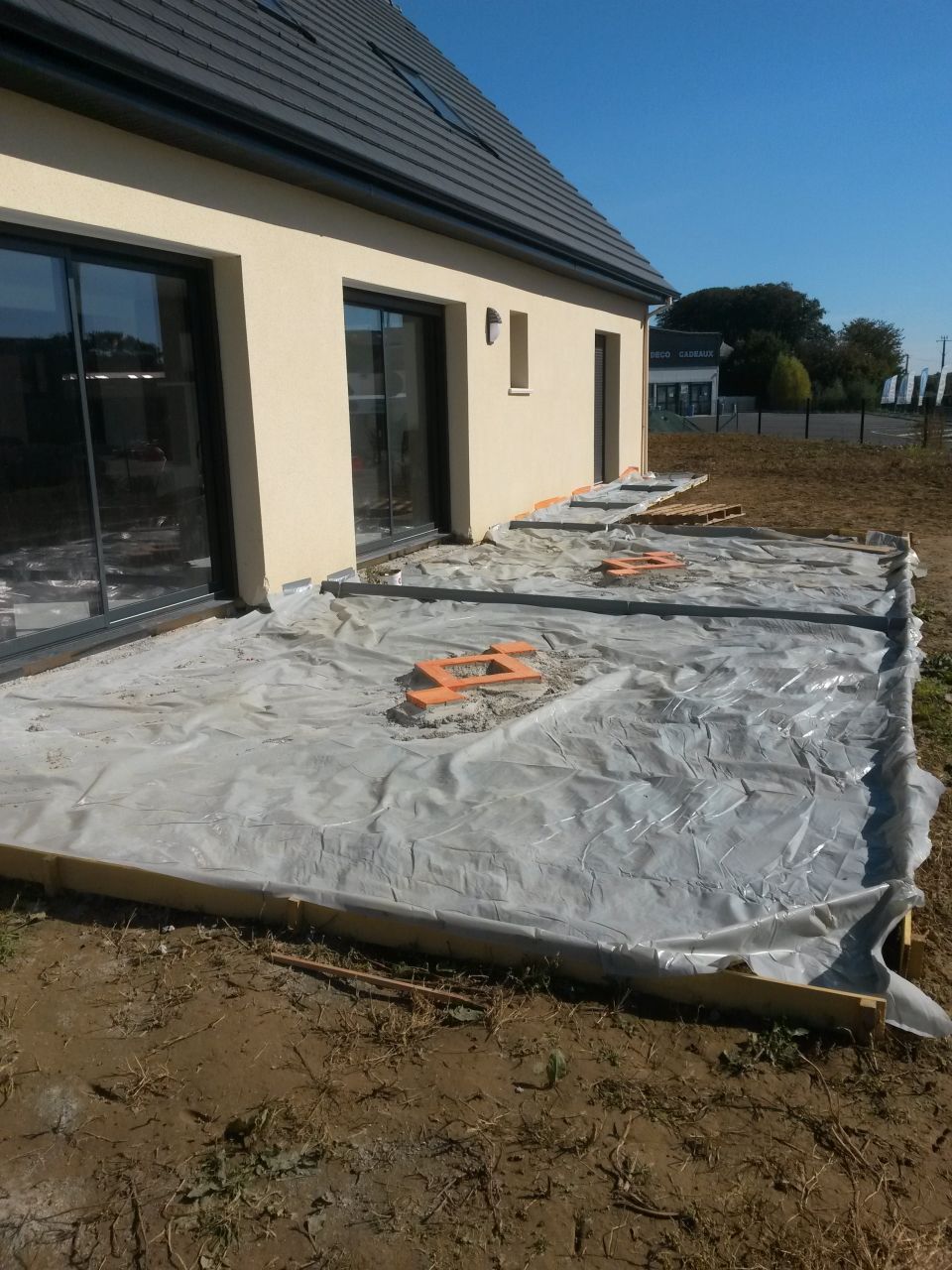 Terrasse en béton noir, motifs avec pavés de rue
<br />
Préparation pour le coulage, polyéthane, joints et protection des pavés.