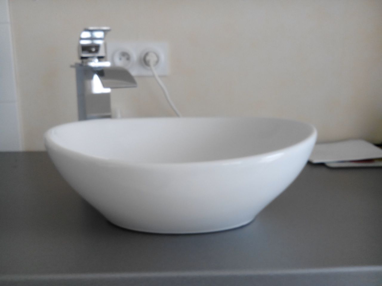 Vasque et mitigeur reçu, posés sur le plan qui servira dans la salle de bain