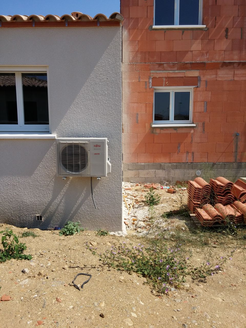 Normalement le compresseur devait être au sol mais comme ils ont oublié d'envelever les 30cm de terres de coté et les 50 en face, c'était plus simple de la mettre la ben oui... Manque de bol le maçon ne peut pas poser le mur mitoyen car il manque 3CM et encore sans pouvoir intervenir sur la Clim en cas d'entretient...
<br />

<br />
De toute façon c'est pas grave ça tombe pas en panne, en cas de problème vous avez le tuyau d'évacuation topissime juste dessous, il évacue tous vos soucis!