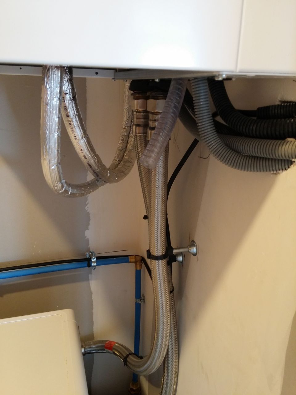 Module PAC intérieur du plancher chauffant: Trop plein qui se déverse sur la machine à laver, le top pour réduire sa consommation d'eau de lavage!
<br />

<br />
Très bel insertion des gaines dans la cloison juste sous le nez, du plus bel effet. J'ai préféré couper une partie de l'image pour les âmes sensible. :p