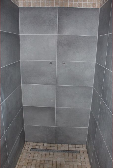 Carrelage de la douche à l'italienne dans notre salle d'eau. Même couleur de carrelage qu'au sol avec la frise en plus