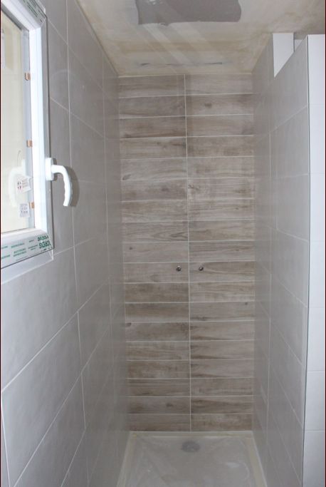 Carrelage de la douche à l'étage avec au fond, le même carrelage qu'au sol