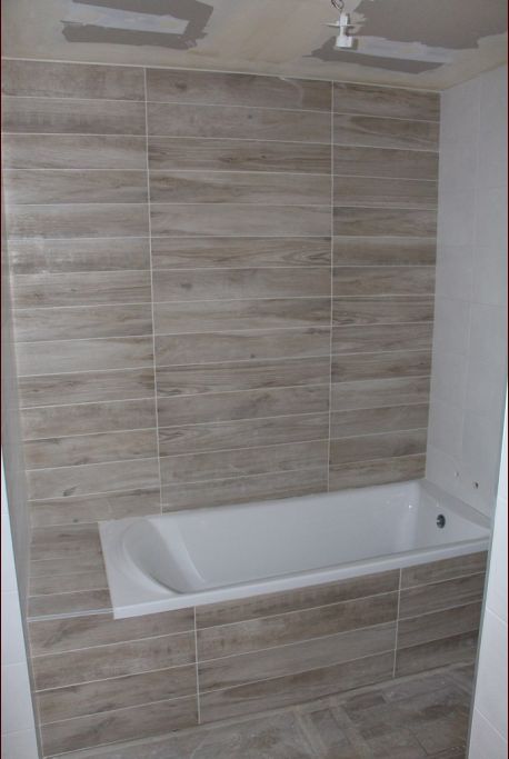Carrelage de la baignoire à l'étage avec au fond, le même carrelage qu'au sol
