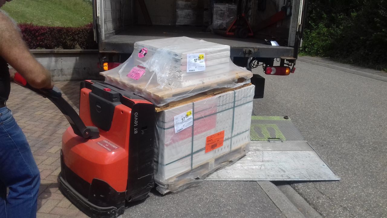 Camion avec hayon élévateur et transpalette électrique.