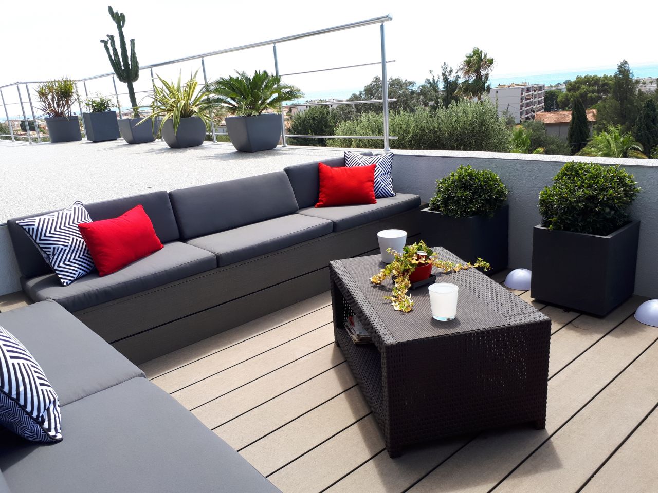 Terrasse encastre termine avec les coussins fait sur mesure et les plantes