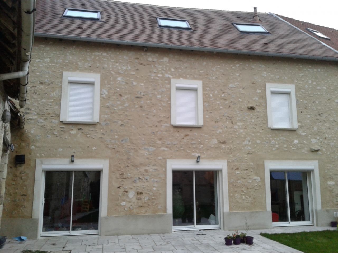 Petite photo de la façade termninée, toiture terminée et Volet roulant posé