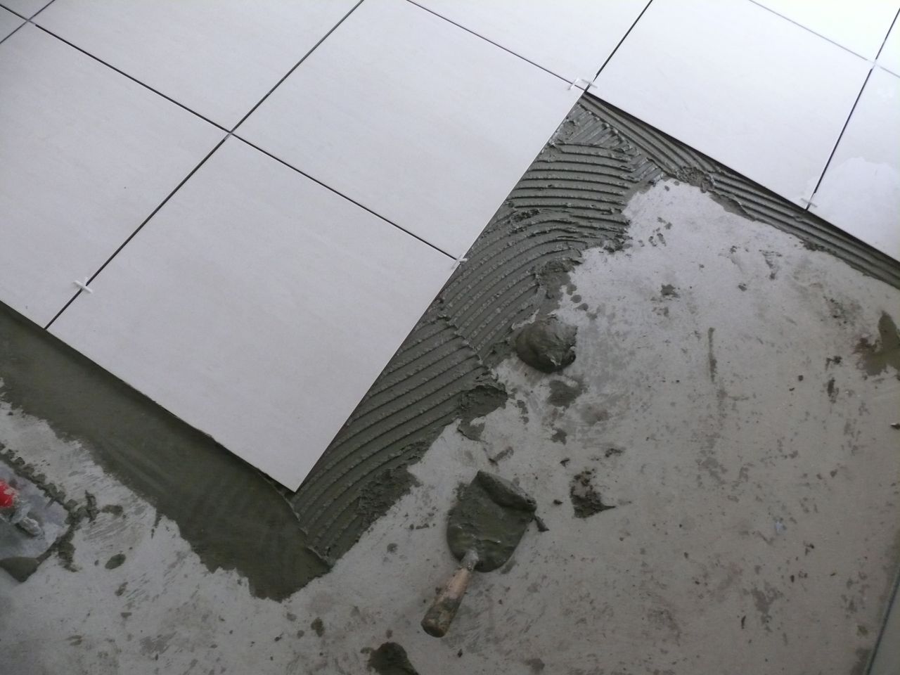 Le carrelage est en cours de pose dan la cuisine