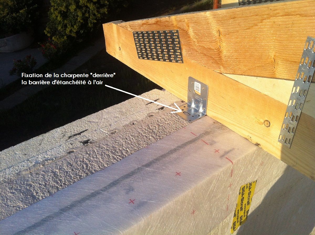 Pose et fixation charpente fermette derrière la membrane d'étanchéité à l'air toiture.