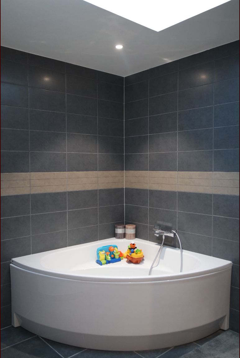 La baignoire sous le puis de lumière velux