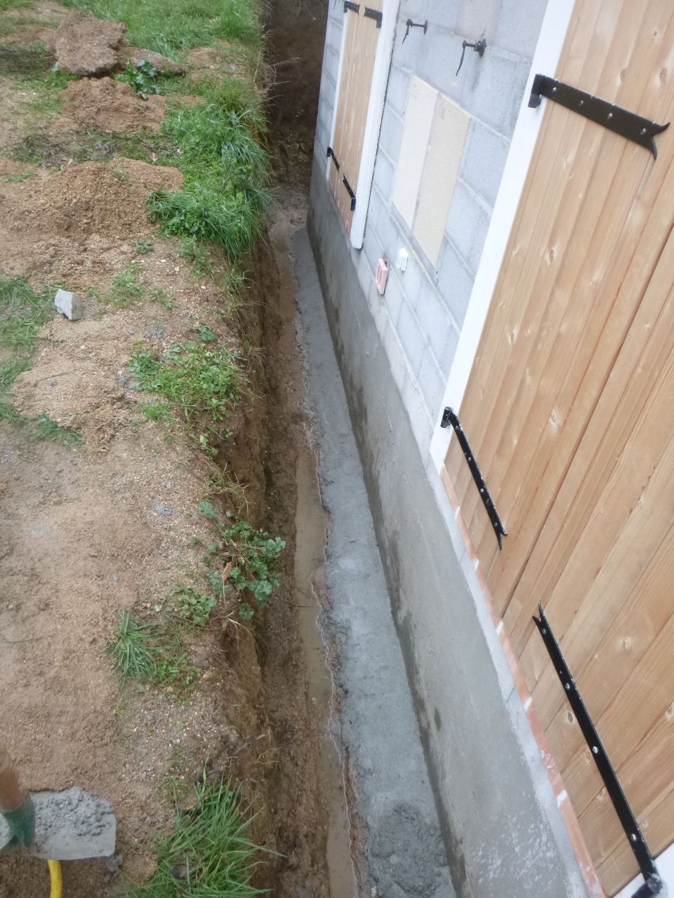 réalisation d'un chanfrain (petite pente sur la fondation) pour écarter l'eau de la maison.