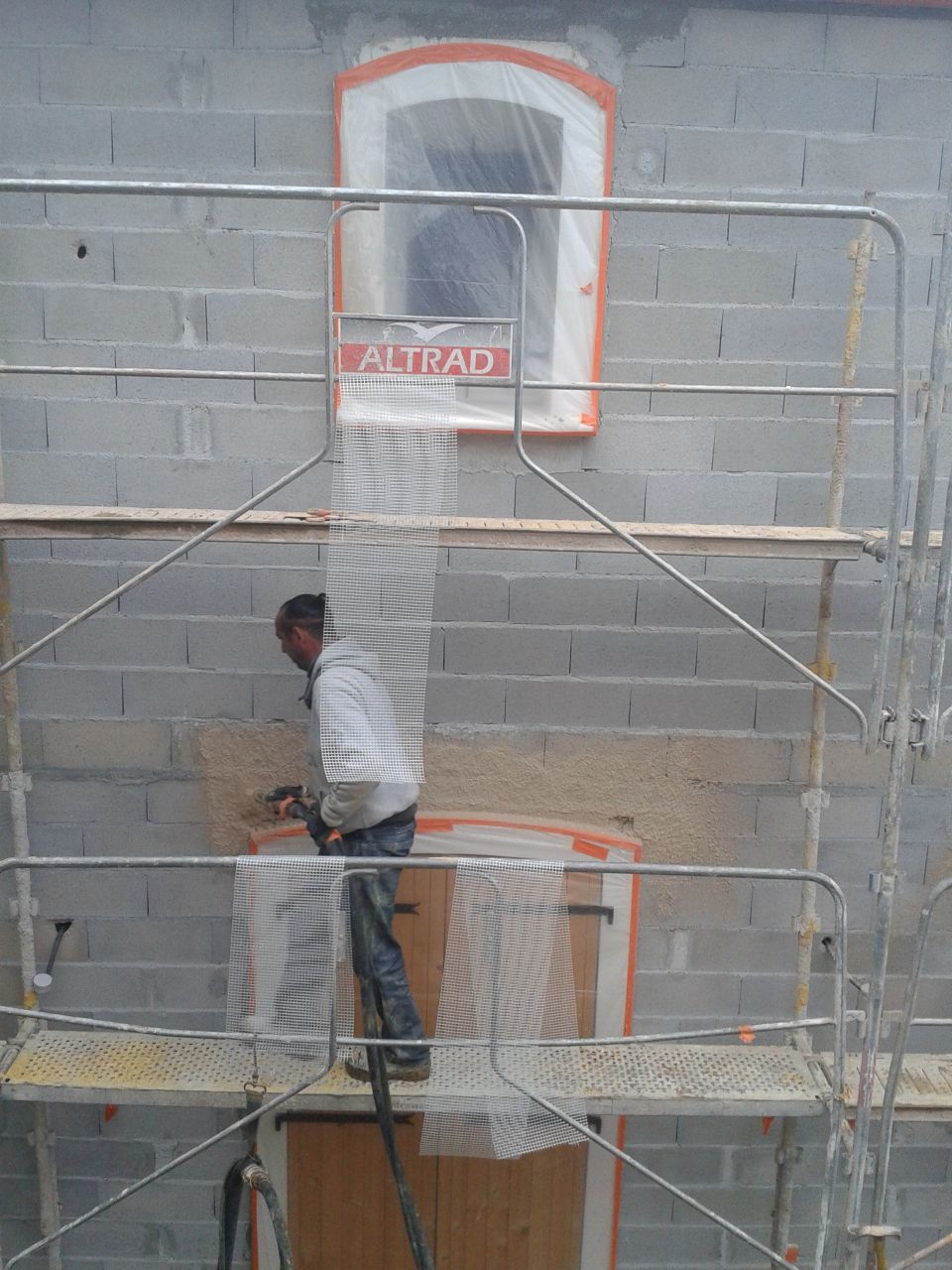 mise en place de grillage entre le linteau des ouvertures et les agglos.