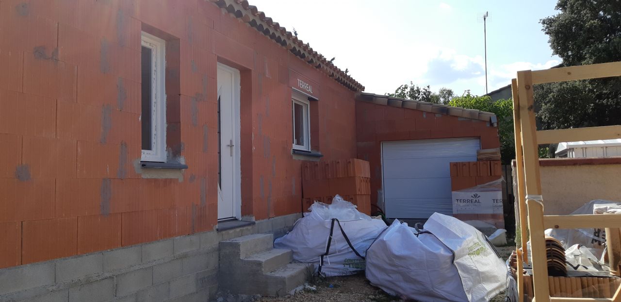 Côté entrée : Porte du garage + Porte d'entrée + fenêtre salle d'eau + le chantier laissé par les artisans ...