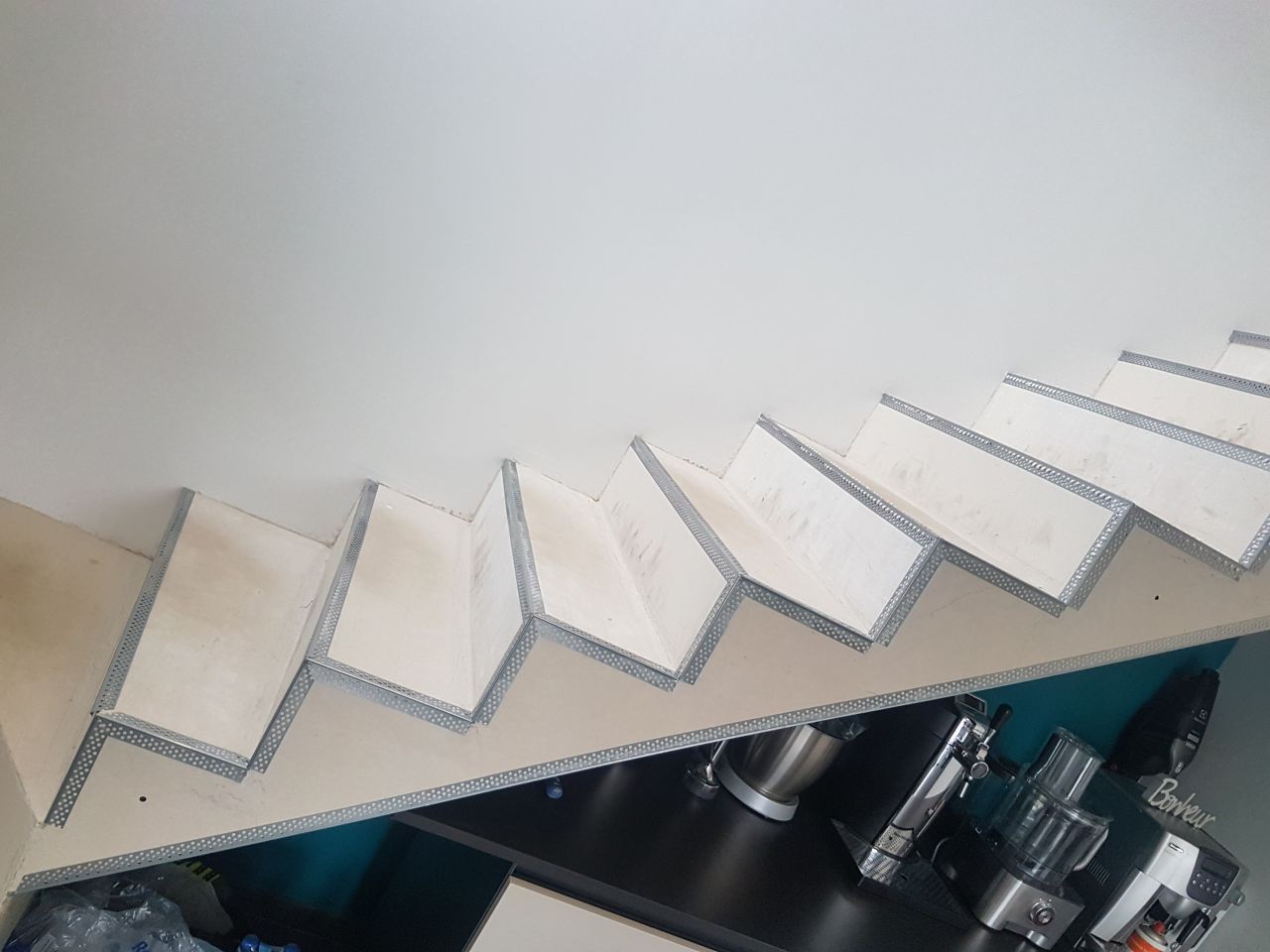Mise en place de baguettes sur l'escalier avant béton ciré