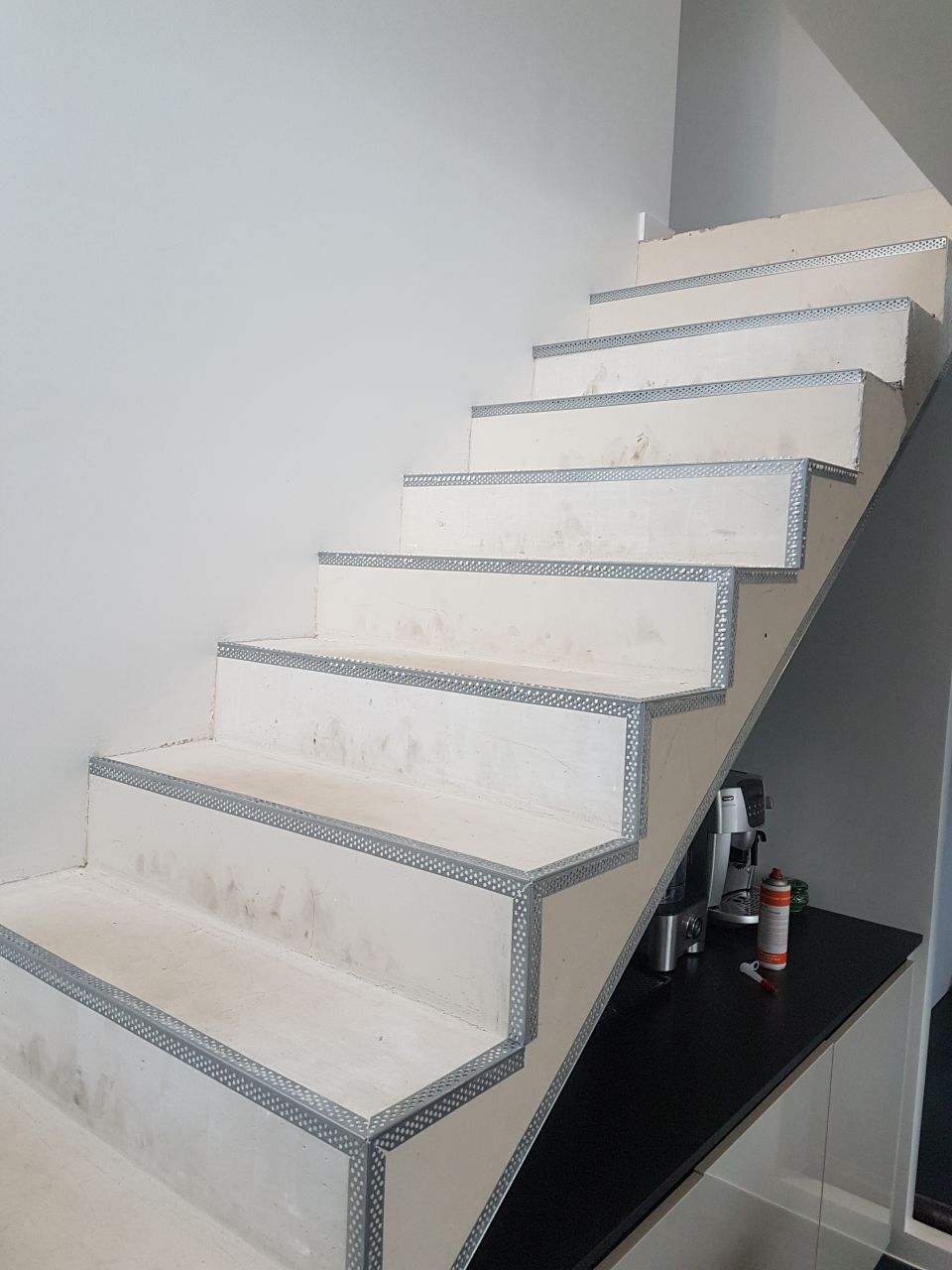 Mise en place de baguettes sur l'escalier avant béton ciré