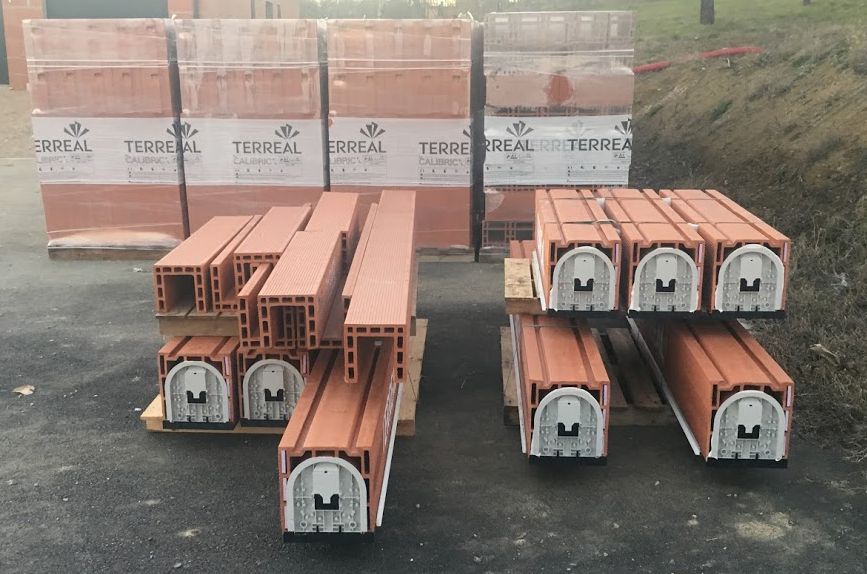 Arrivée des briques, des coffres pour les volets roulants et des linteaux pour les ouvertures.