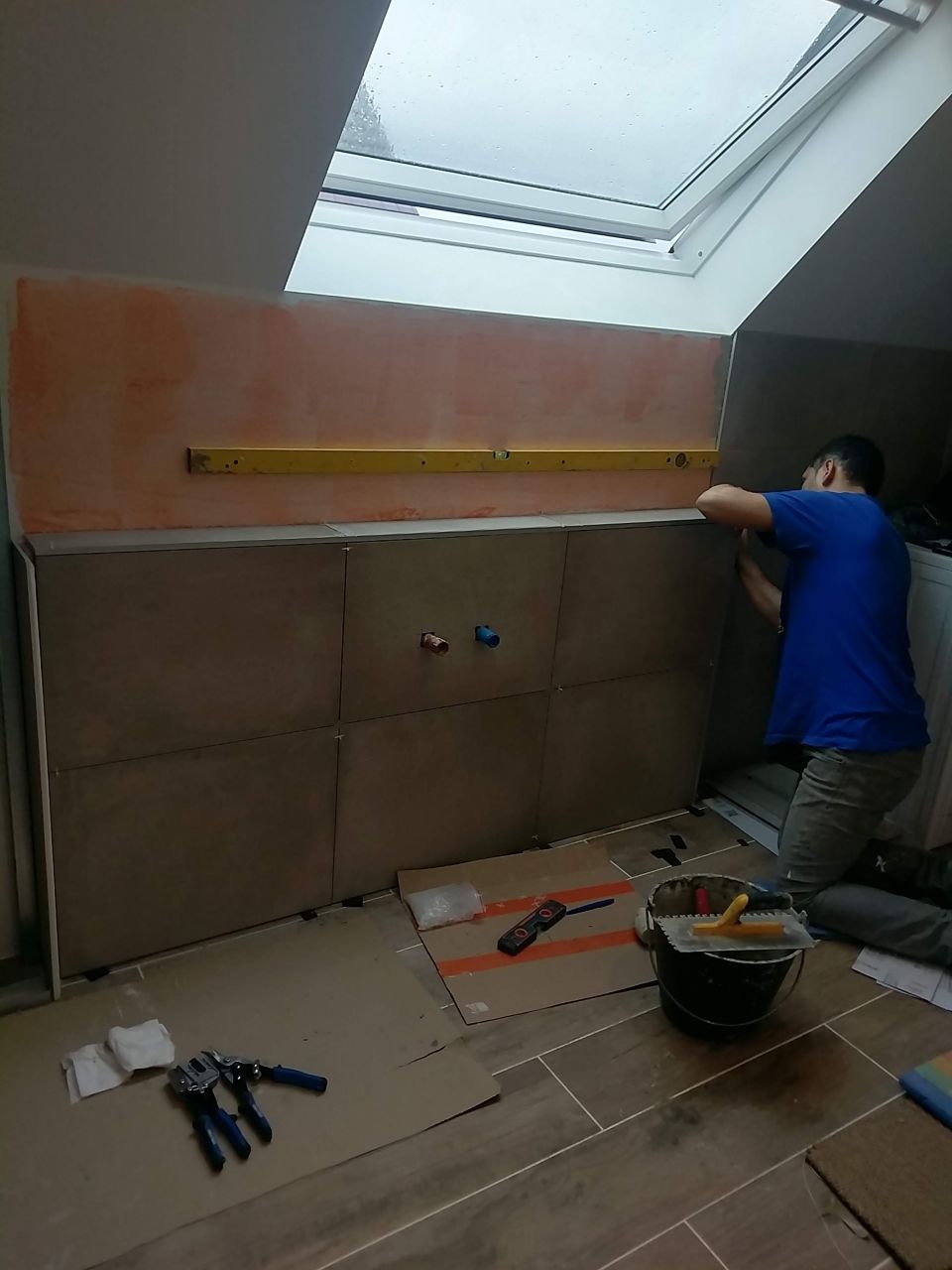 Pose du carrelage mural de la salle de bain en cours