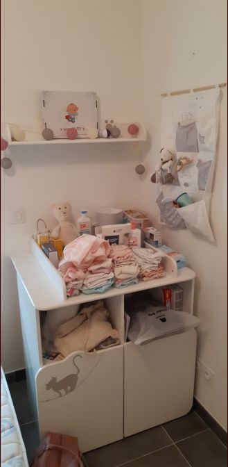 Commode à langer bien remplie avec sa petite étagère