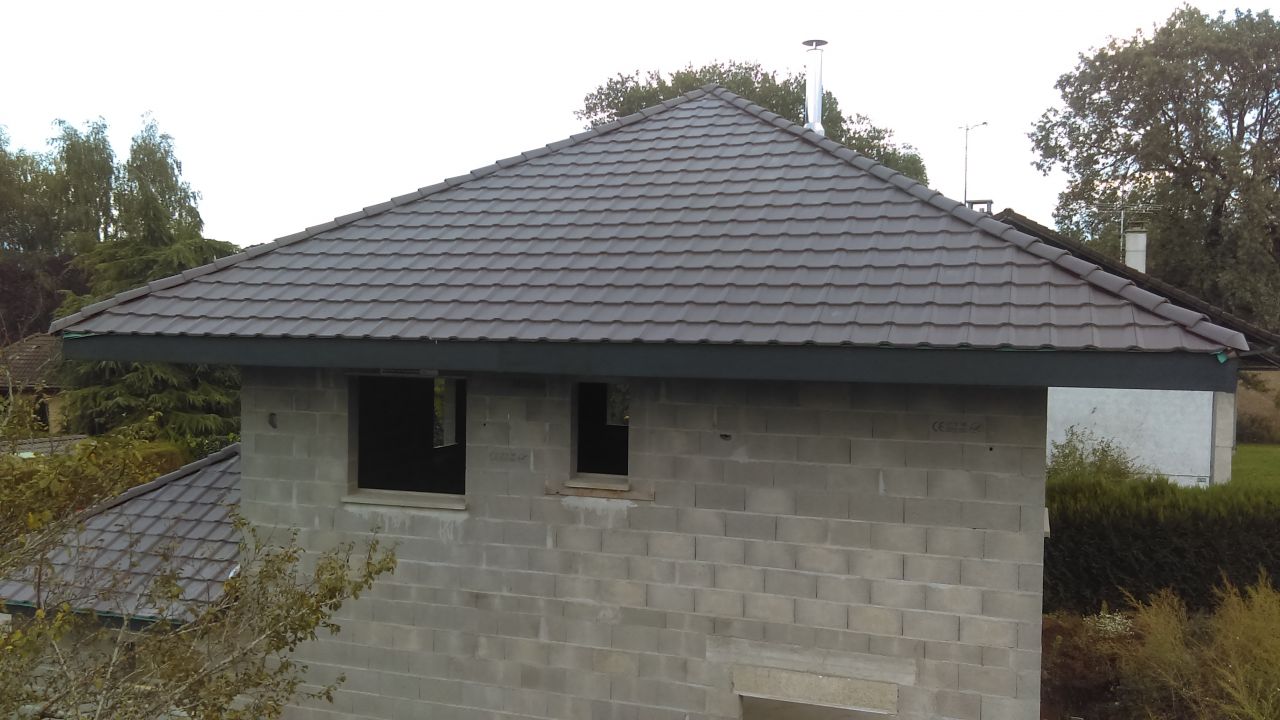 Toiture achevée, tuiles Monier Perspective béton brun.
<br />
Bande de rive et sous face PVC RAL 7016.