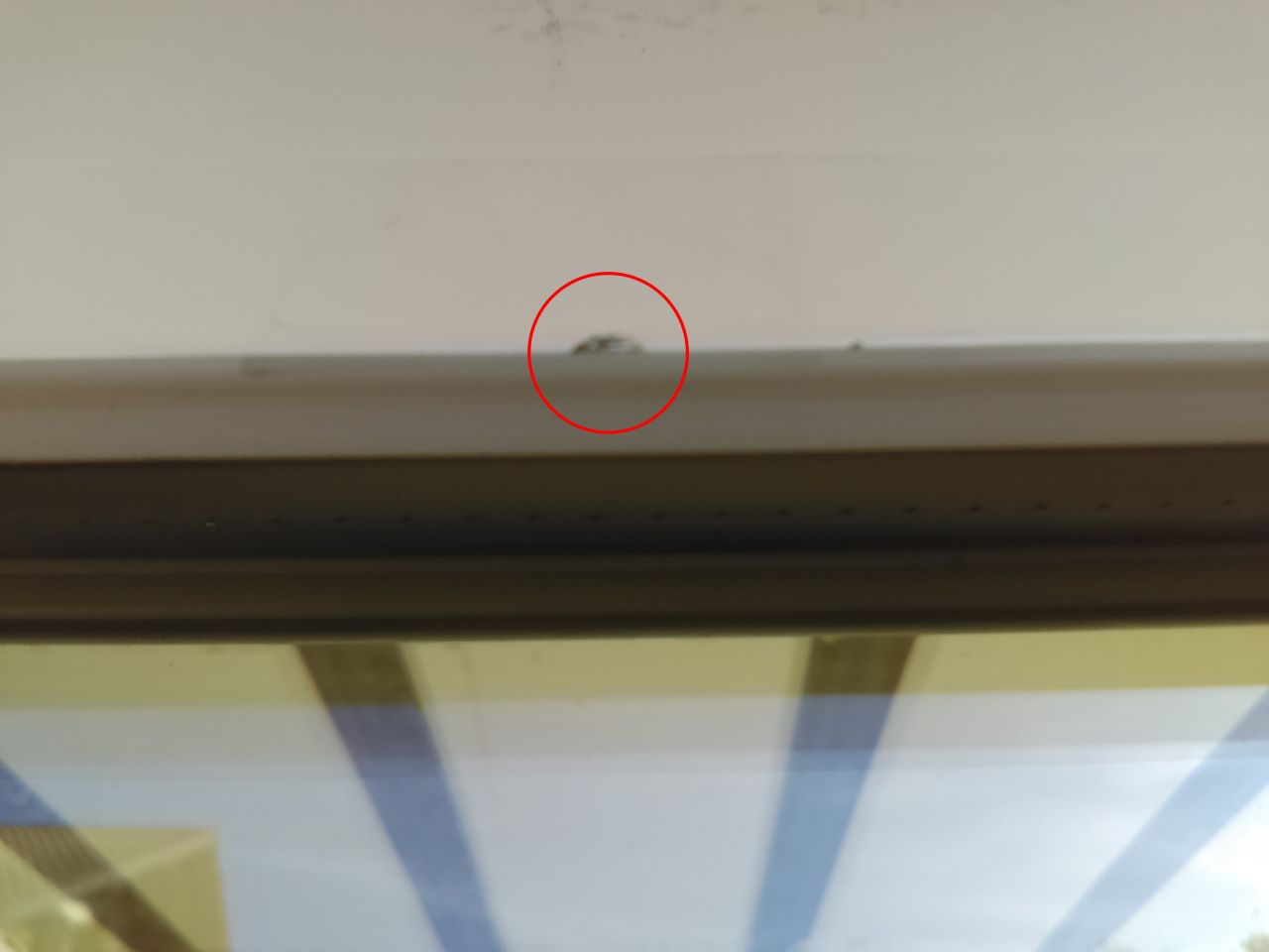 Éclat dans la peinture du cadre de la baie vitrée Sud.