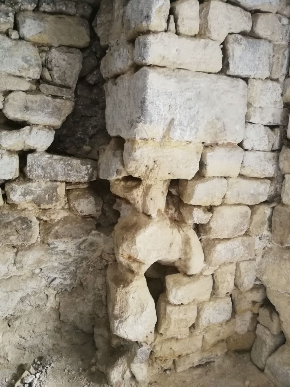 Vue serre d'un poteau mis  nu de ciment avec pierres trs uses