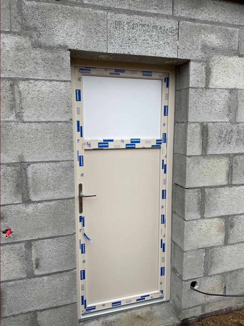 Porte de service posée (oculus en attente de livraison, couleur beige pour respecter le PLU qui n'accepte pas le blanc)
