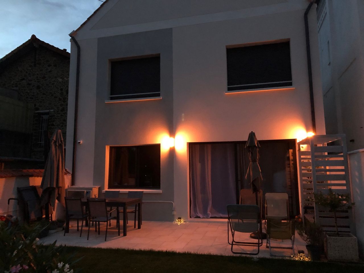 Ambiance lumineuse orangée sur la terrasse en soirée