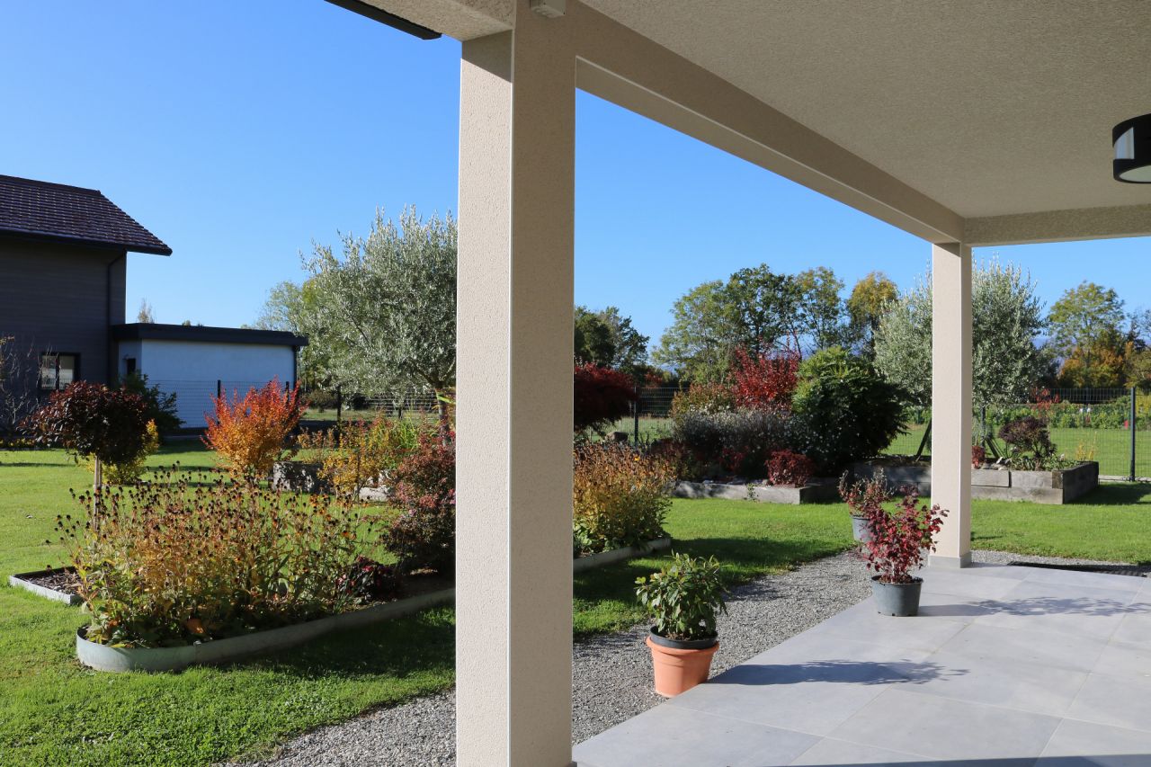 Prolongement de la terrasse couverte vers l'Ouest et son moutonnement inégal d'arbres et arbustes
