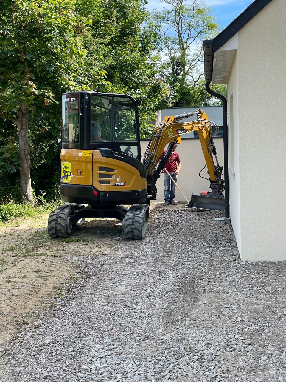 Avant de le tasser, on gratte le sol pour arriver pile au bon niveau de pose des structures en nid d'abeille qui vont recueillir les graviers bicolores, on évacue le surplus.