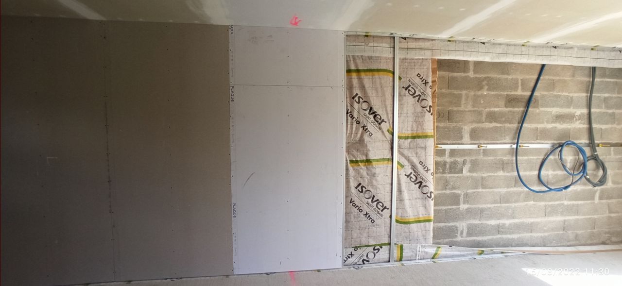 1 photo, 3 étapes:

- mur brut

- laine de verre et membrane d'étanchéité

- plaqué en BA13