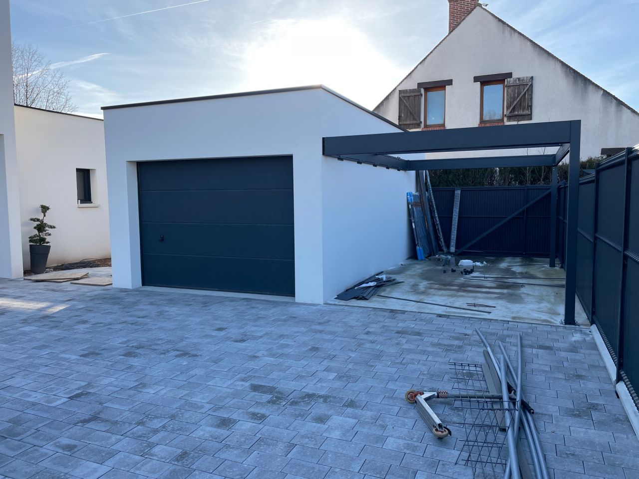 Cour en pavé terminée, montage du carpot en cours