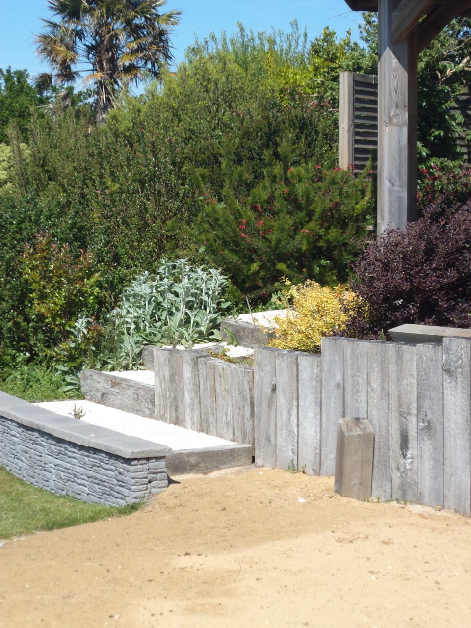 L'accès à la sable de sable par l'escalier en gravillons lavés bordures en poutres de chêne