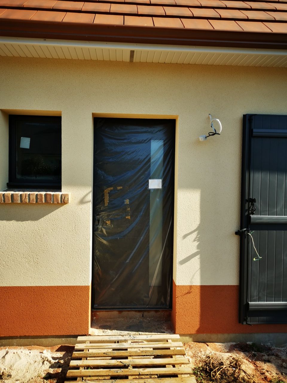 11 10 2024 OUBLI de pose de l'enduit ton tuile autour de la porte d'entre et petite fentre / l'enduit autour de la porte n'est pas droit / encore une fois, le constructeur ne ragit pas lorsque nous lui en faisons part