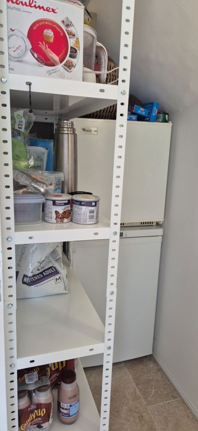 Petit cellier sous escalier pour rangements et congélateurs.