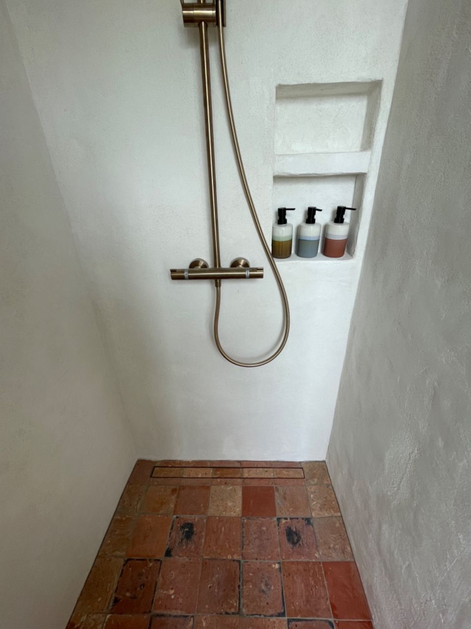 Douche italienne en tomettes anciennes, mur en chaux sable.