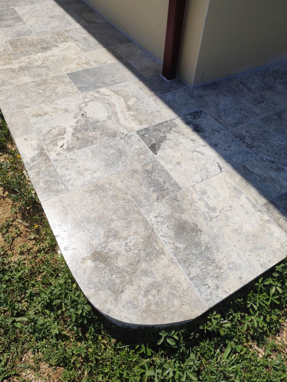 Trottoirs en travertin gris, recouverts d'un produit hydrofuge et oléofuge ?