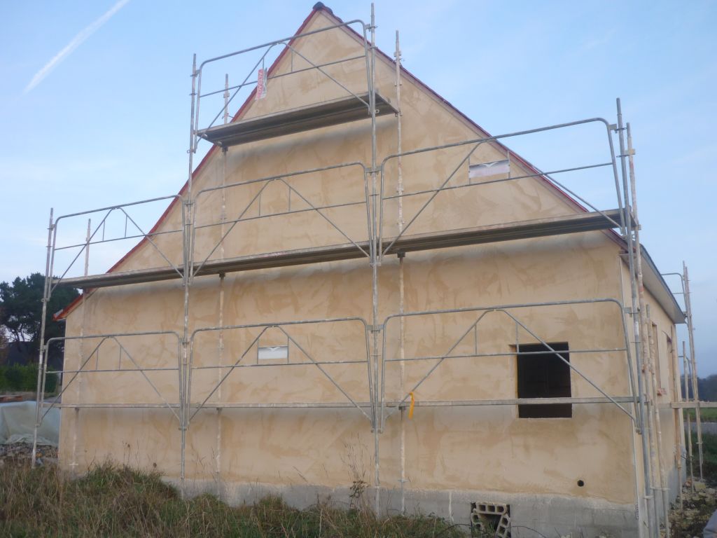 Premire couche de l'enduit.Les murs vont tre recouverts d'un enduit tanche. Notre enduiseur utilise les produits Weber-Broutin et travaille en deux couches.Protection des portes, des fentres, le dessous des ardoises, la toiture.La couleur est jaune opale J30.