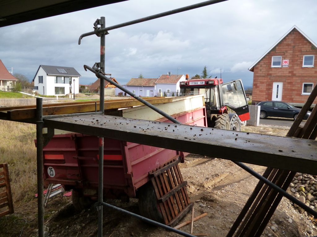 Etanchéité du garage: mise en place du gravier de lestage. Le gravier a été monté à la pelle de la remorque jusqu'à la brouette placée sur le toit
