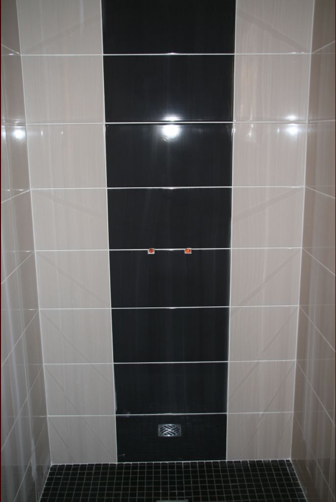 SDE parents : douche : la colonne avec le mitigeur et le dôme de pluie devraient bien trancher avec la bande de carreaux noirs