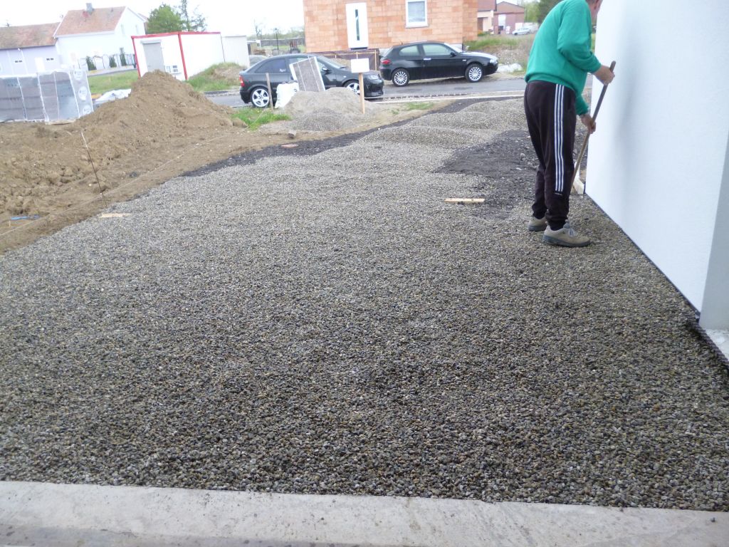 Ratissage du concassé de finition le long de la maison