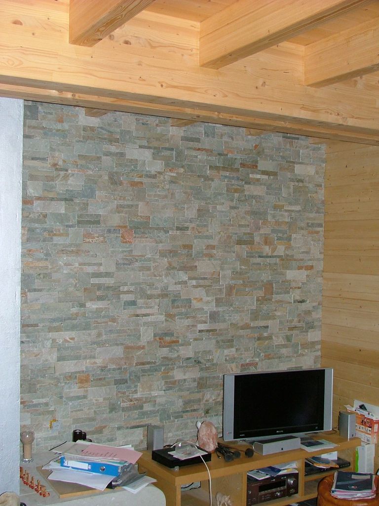 mur en pierre de parement à côté de la cheminée dans le salon