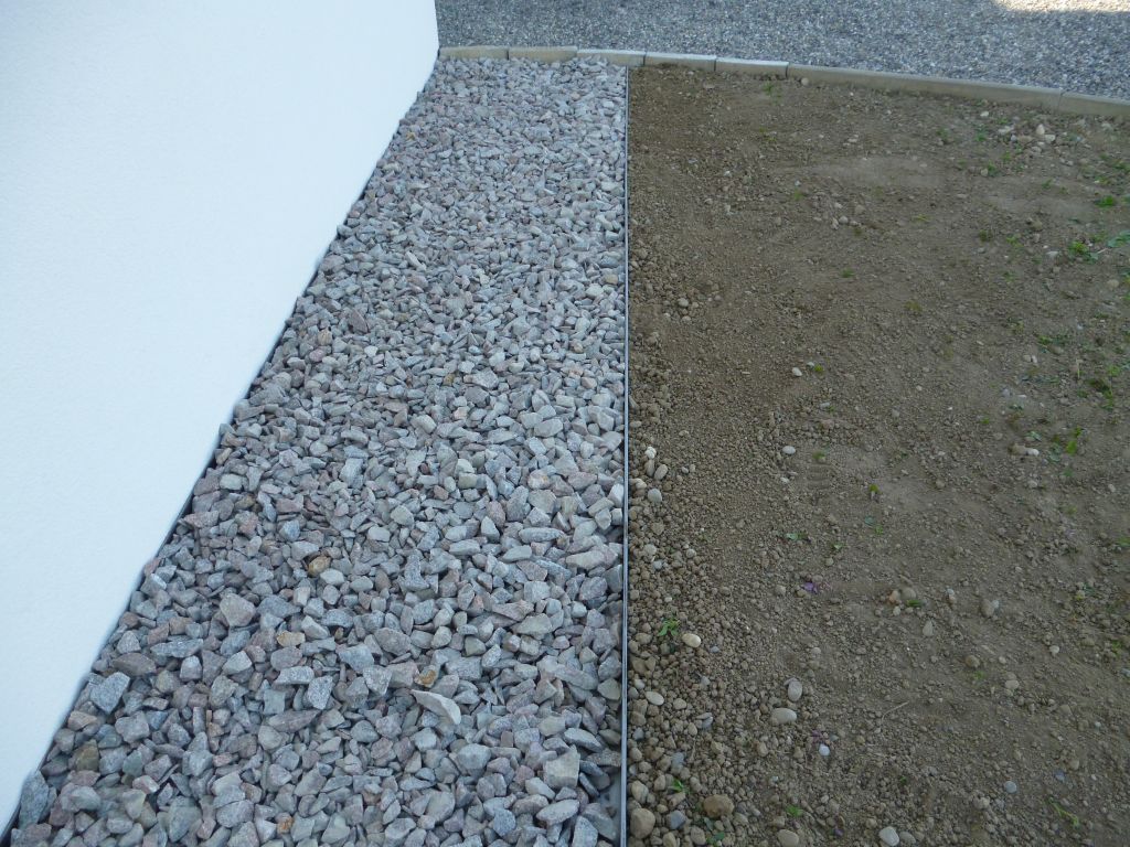 Aménagements extérieurs: Pose d'arrêts pelouse entre futur gazon et bordure en cailloux de granit