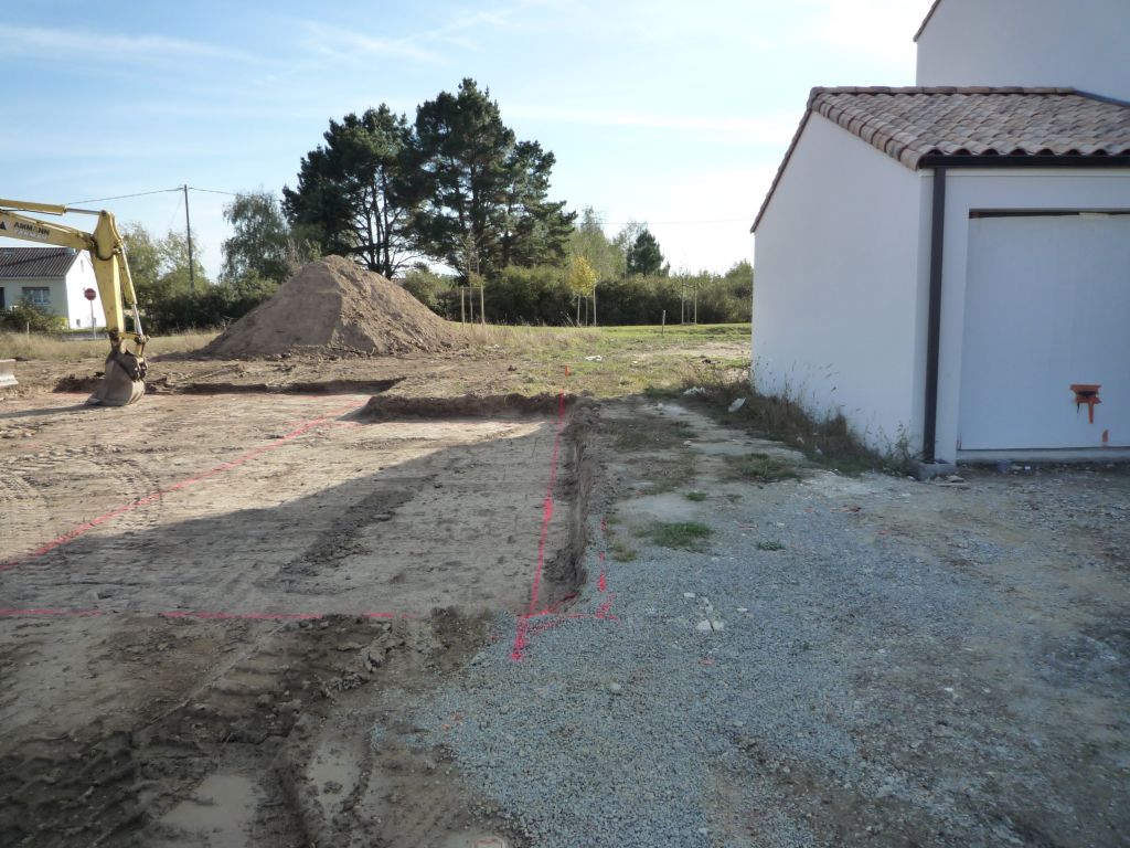 La maison du voisin a commencé. Le trait rose, c'est la limite du terrain.