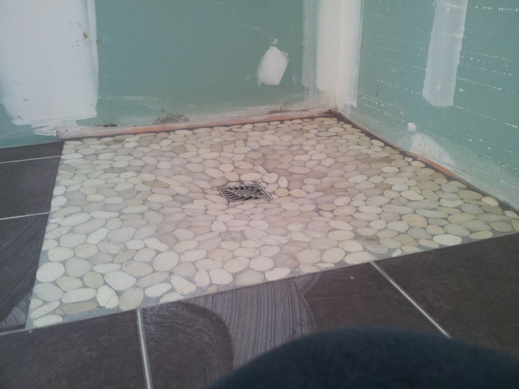 Les galets de la douche à l'italienne "Blancs KXFLAT" de chez Tanguy.