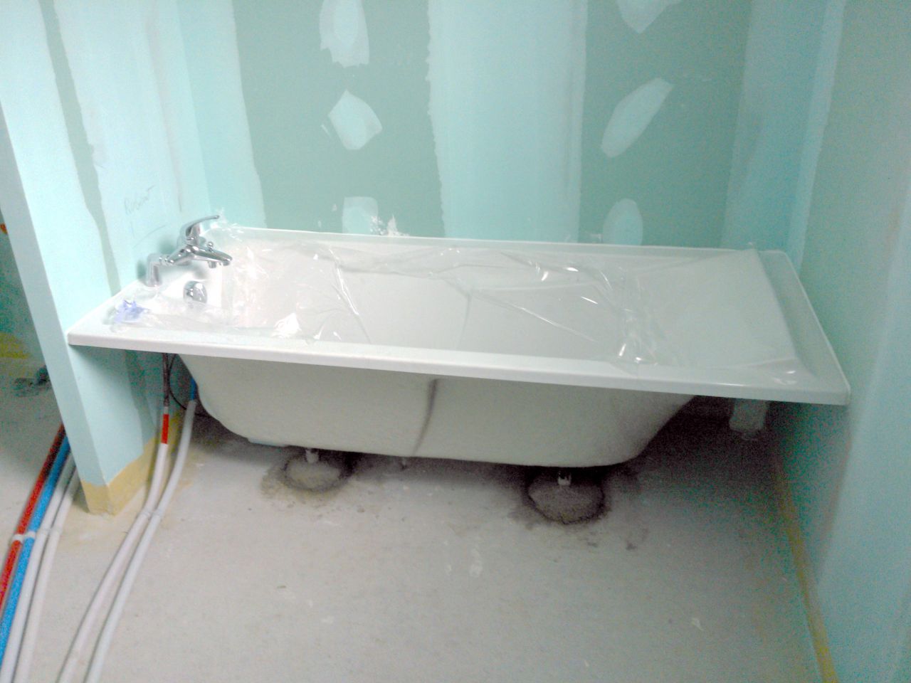 La baignoire passe pile-poil (1m70).

Les pieds sont très bien scellés dans le béton, ça bougera pas !