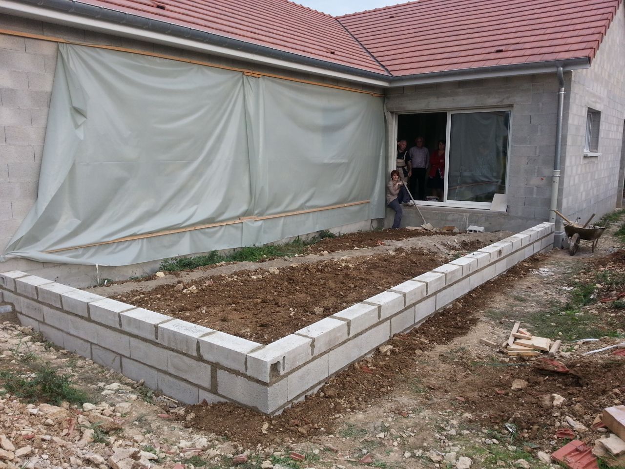 le mur qui va accueillir la terrasse est terminé... ma femme est venue me donner un coup de main pour recouvrir le tuyau d'évacuation... j'ai terminé ensuite en nivelant tout ça (belle ampoule aux mains en fin de journée ^_^  !!!! )