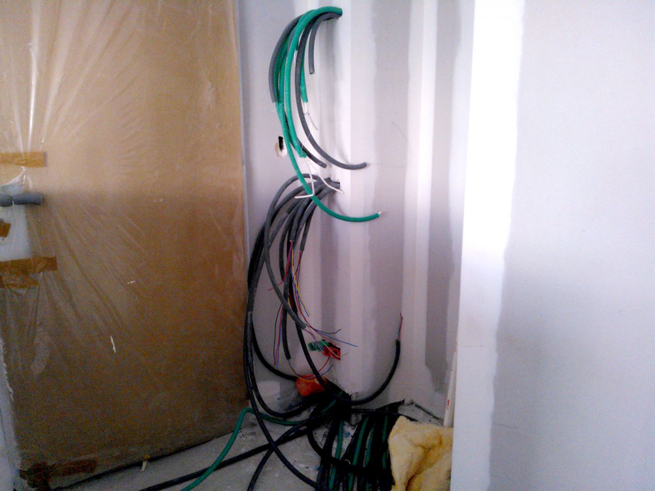 La tableau électrique en cours. Très bonne organisation des fils par l'électricien qui profite du caisson pour tout camoufler. En haut les prises TV et RJ45 (en attente de la box et du routeur), au milieu les disjoncteurs et en bas les réserves de gaine pour les futurs projets (piscine, aménagement du garage un de ces jours, peut-être...)