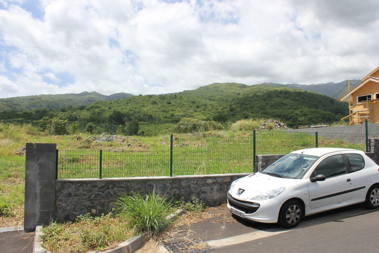 Vue du terrain depuis la rue, notre acces est juste au dessus a droite (pas visible sur la photo, l'entree que l\'on voit est celle de nos futurs voisins).
<br />

<br />
La montagne en face est non constructible pour le moment.