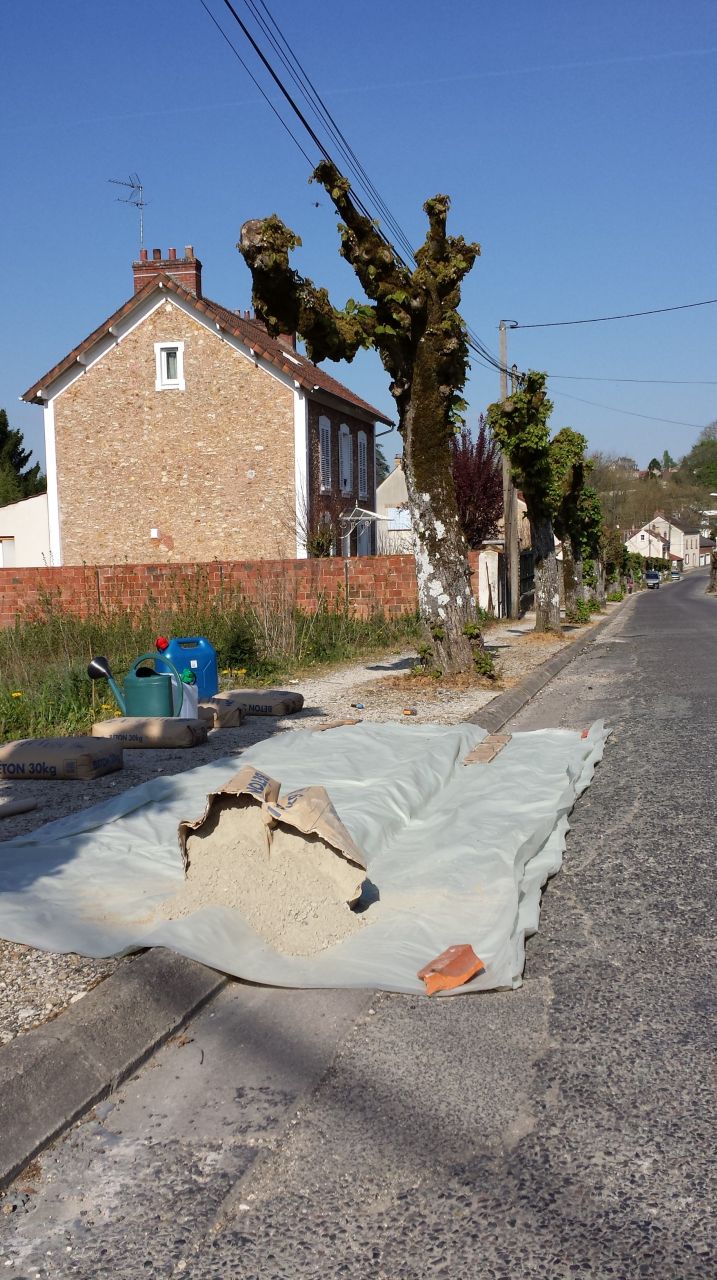 Pose d'une protection de trottoir en bton.