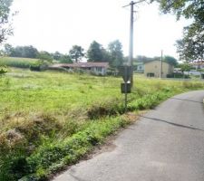 Le terrain se situe sur la gauche, après le poteau électrique.